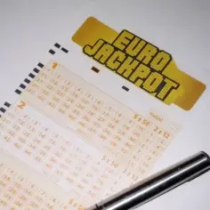 Kupon Eurojackpot z zaznaczonymi liczbami i długopisem.