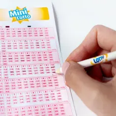 Ręka zaznacza liczby na kuponie Mini Lotto, czekając na losowania lotto kiedy nastąpią.