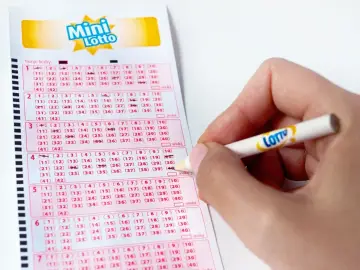 Ręka zaznacza liczby na kuponie Mini Lotto, czekając na losowania lotto kiedy nastąpią.